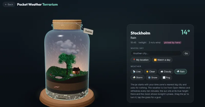 The terrarium at a rainy Stockholm dusk: rain falling on a meadow, a pond and a lamplit cabin inside a corked jar.